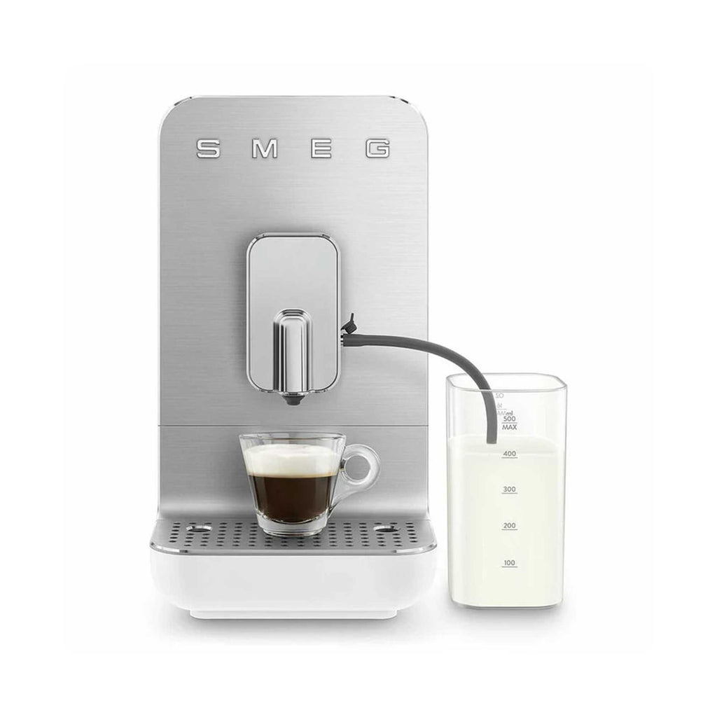 SMEG coffee machine with a cup of coffee and milk pitcher on a white background