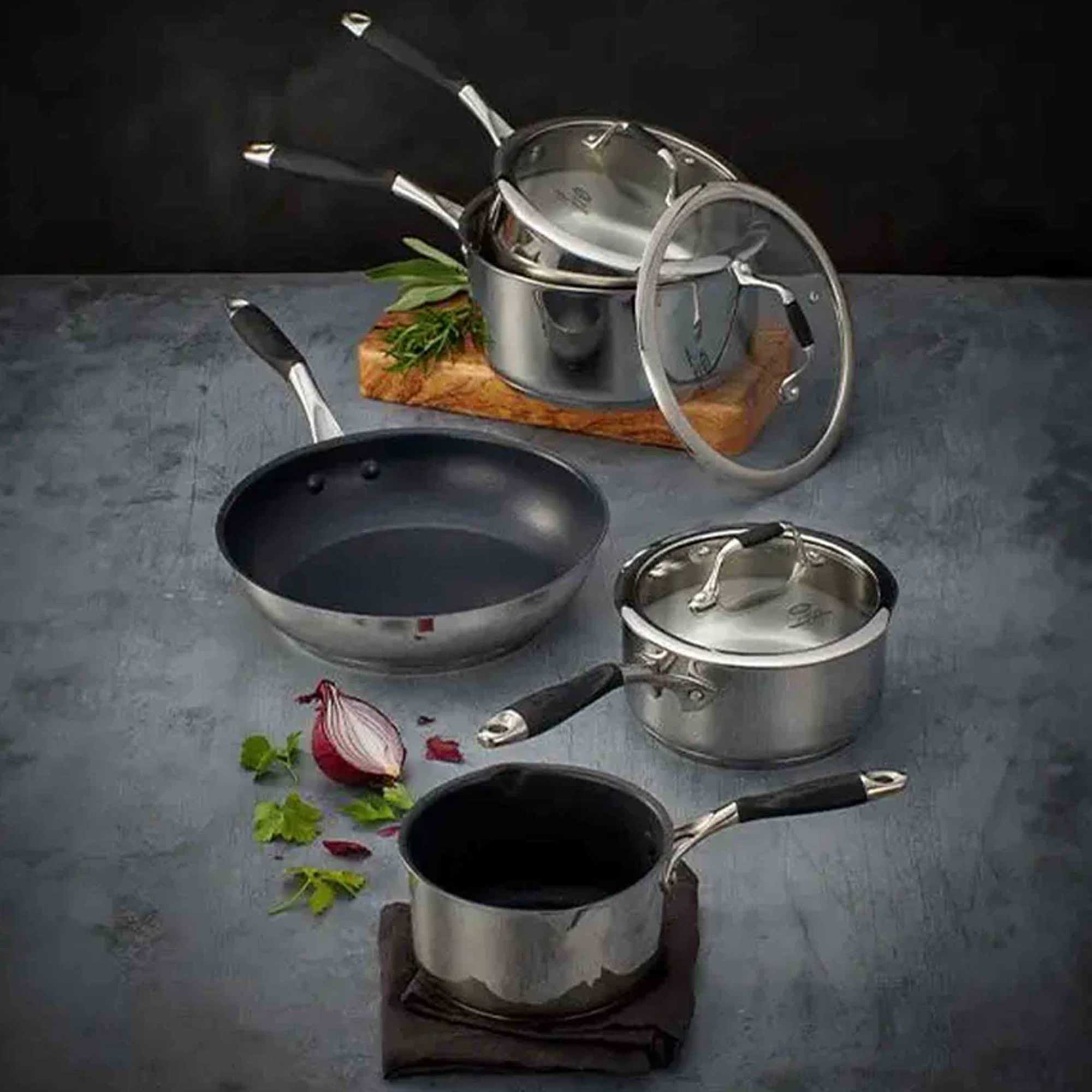 Silver saucepan set on a grey surface and chopping board