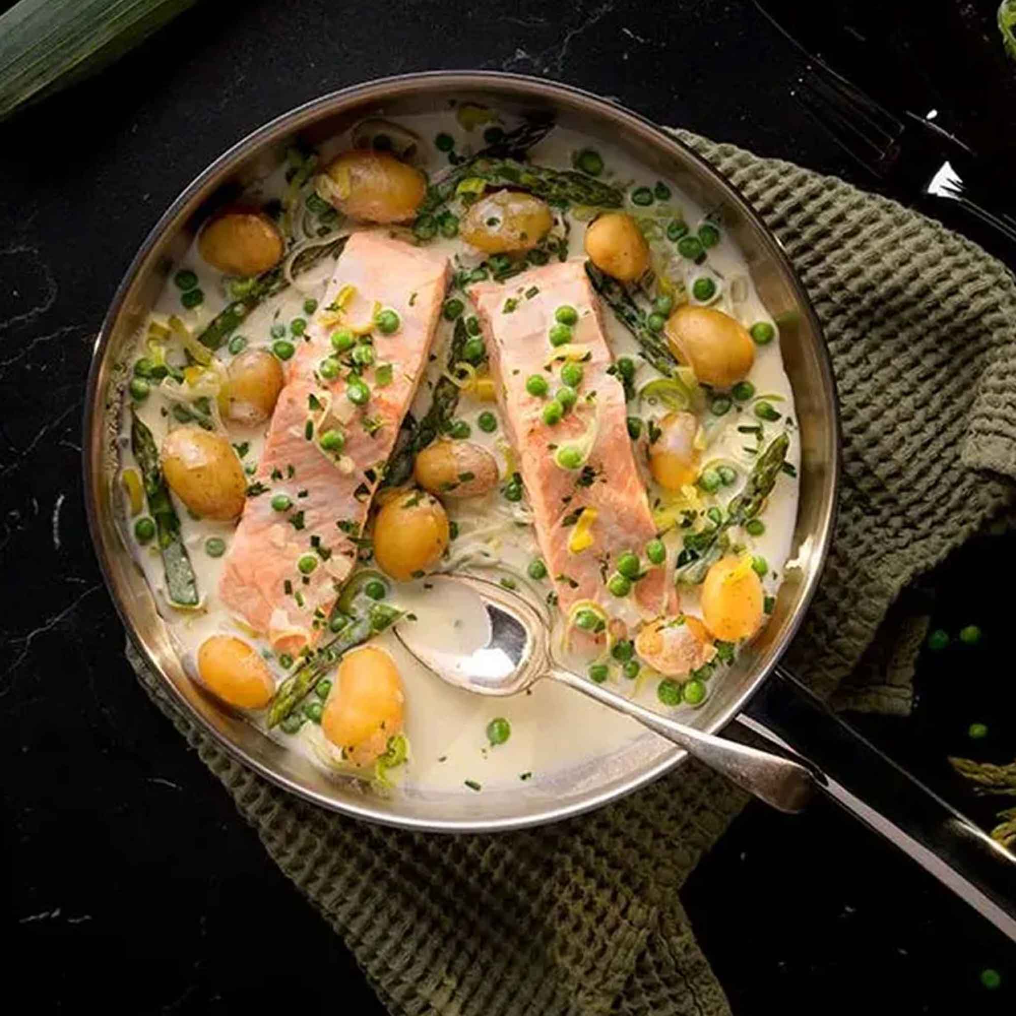 Silver saucepan with salmon in a cream sauce and potatoes