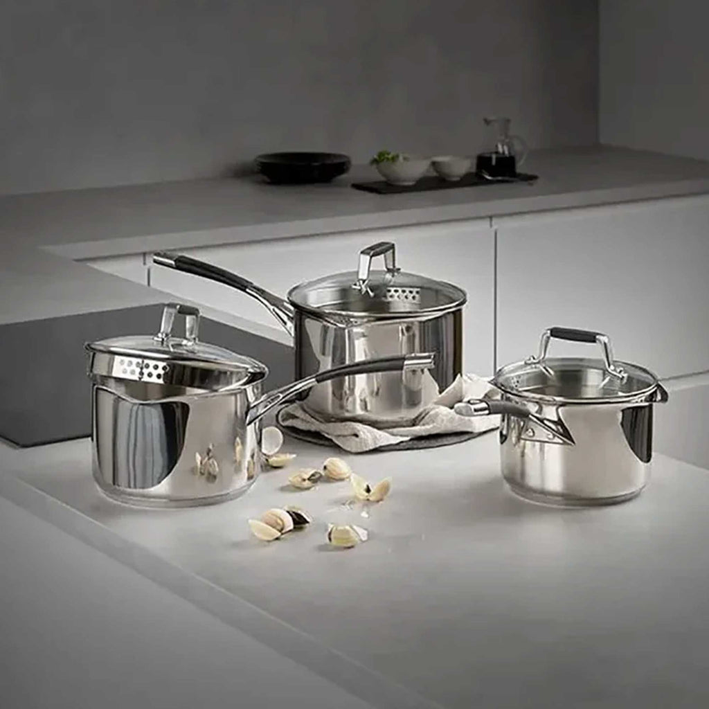 Silver saucepans on a grey worktop