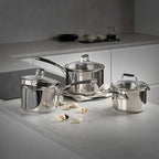 Silver saucepans on a grey worktop