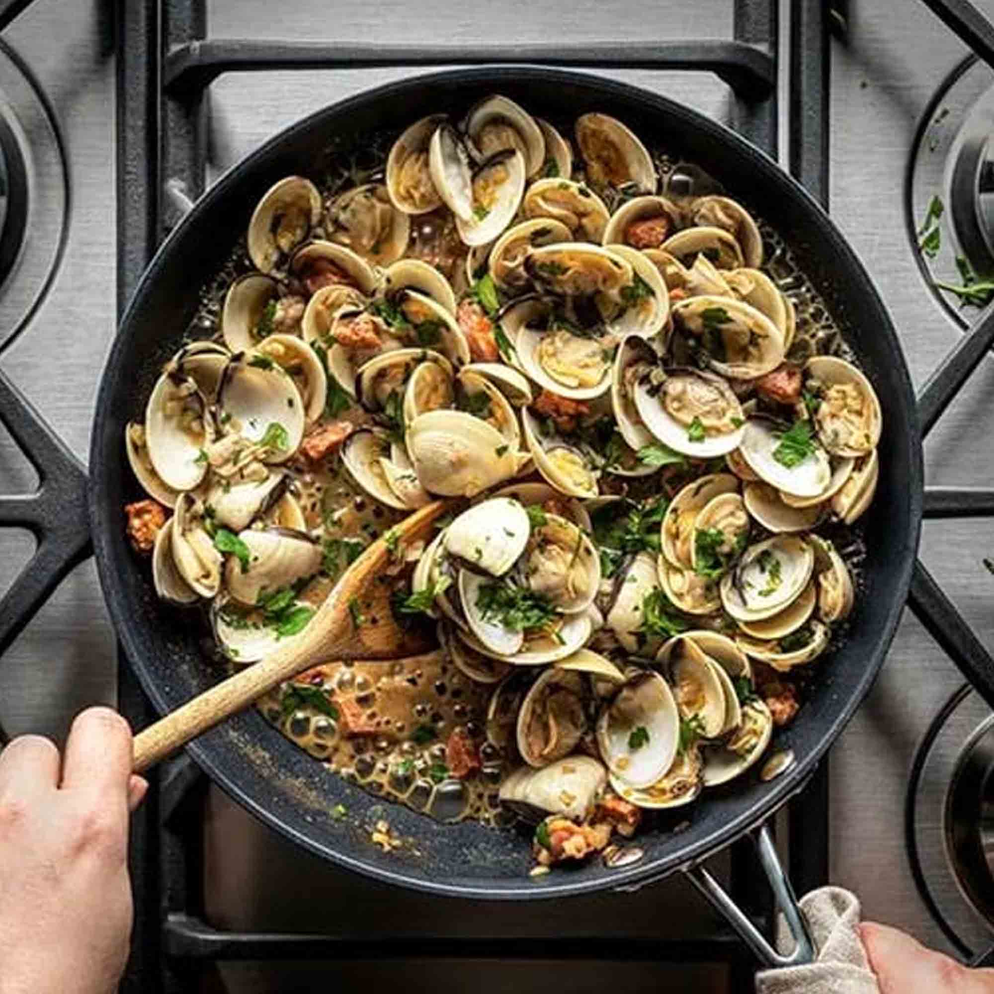 Saucepan with a mussel dish and wooden spoon