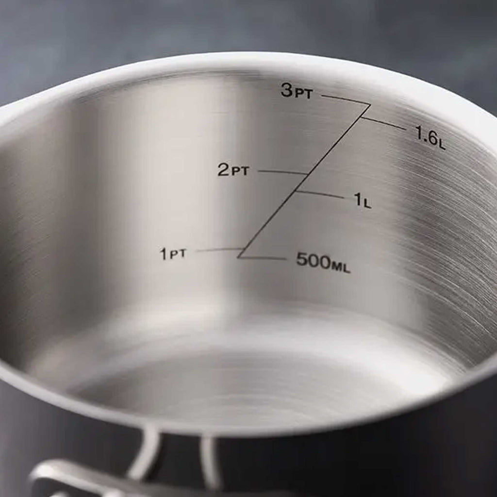 Close-up of the inside of a brushed stainless steel saucepan or pot with printed measurement markings in cups and liters alongside 500ML.