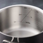 Close-up of the inside of a brushed stainless steel saucepan or pot with printed measurement markings in cups and liters alongside 500ML.