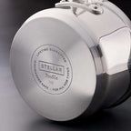 Close-up of the brushed metal base of a stainless steel pot or lid, showing engraved text that reads 'STELLAR Profile 348' and 'LIFETIME GUARANTEE' on a dark studio background.