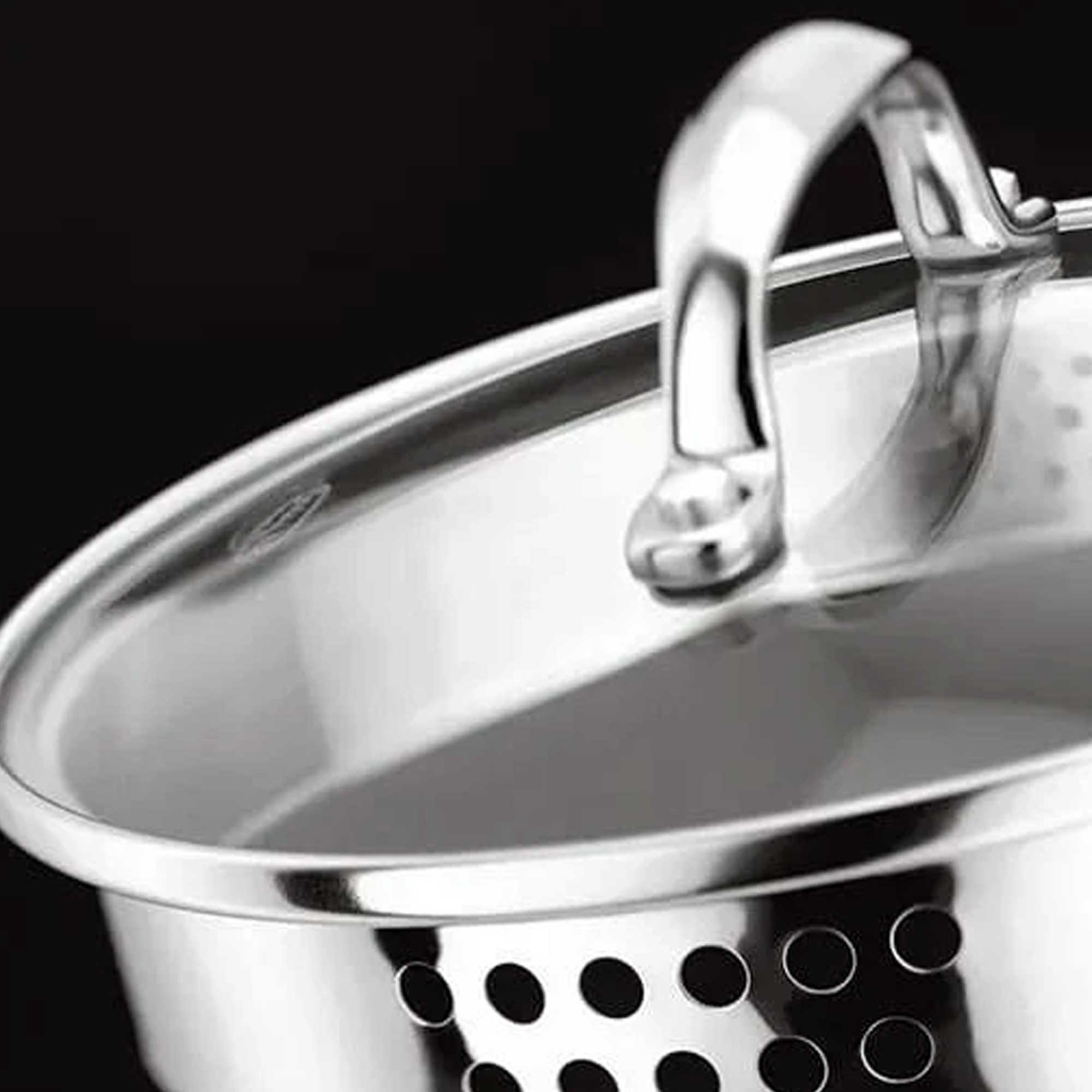 Close-up of a silver saucepan with draining holes with a black background