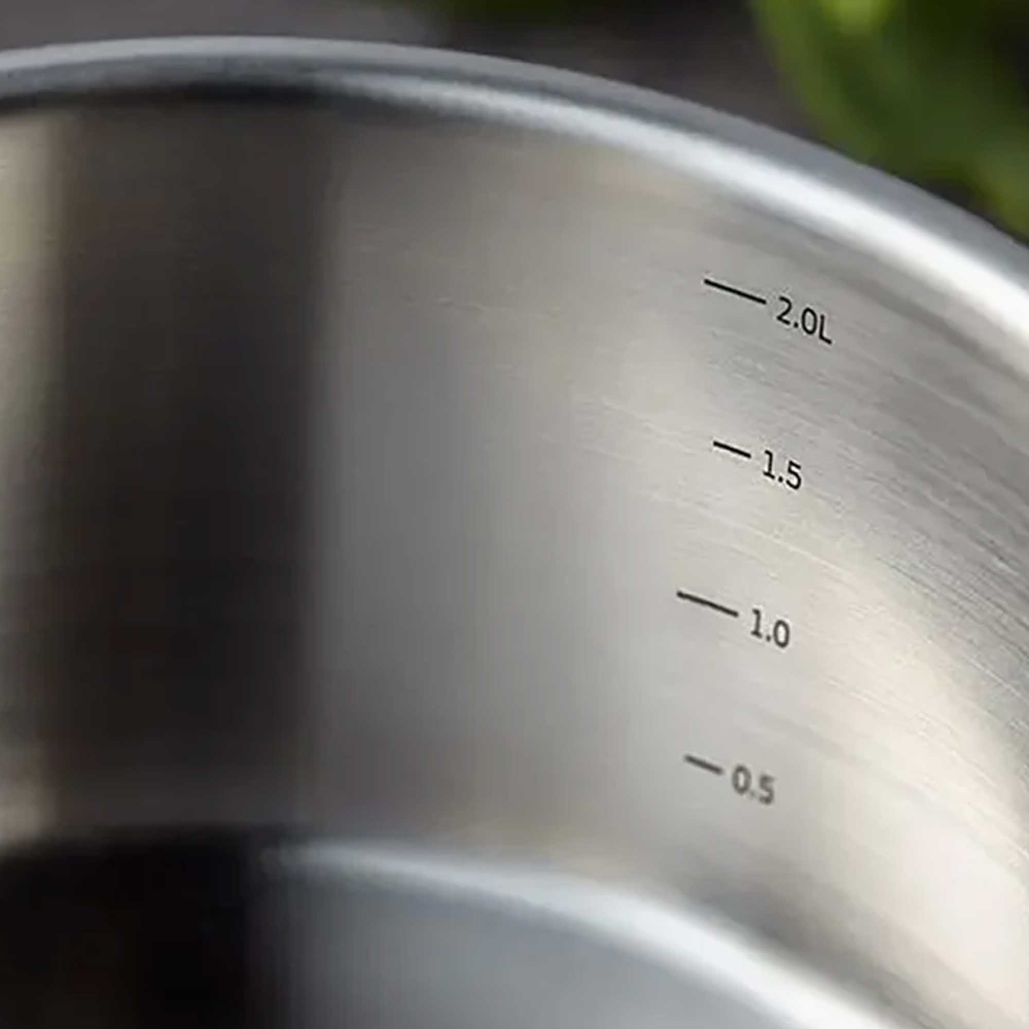 Close-up of a saucepan with volume markings on a blurred background