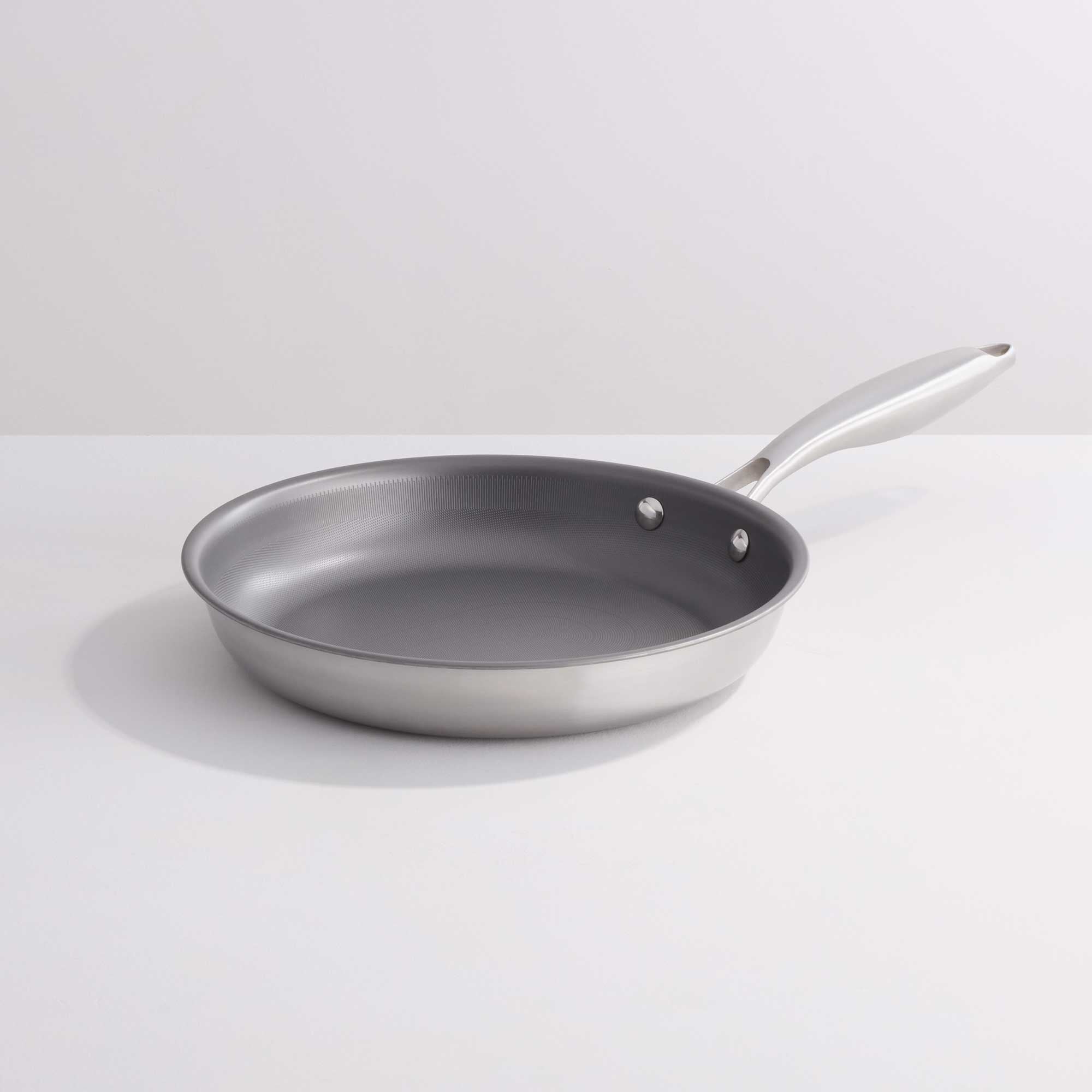 A stainless steel frying pan with a dark gray non-stick interior and a silver handle, shown on a clean white background.