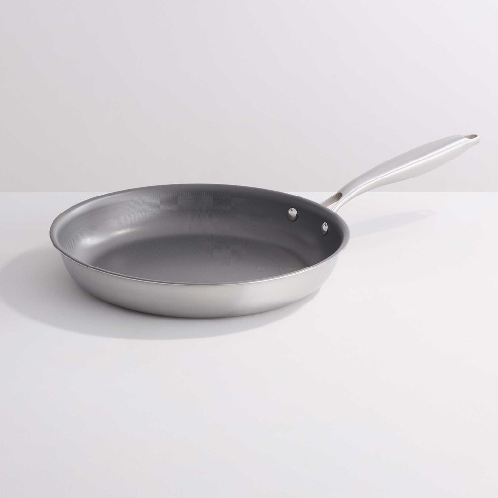 A stainless steel frying pan with a dark gray non-stick interior, shown on a clean white background.