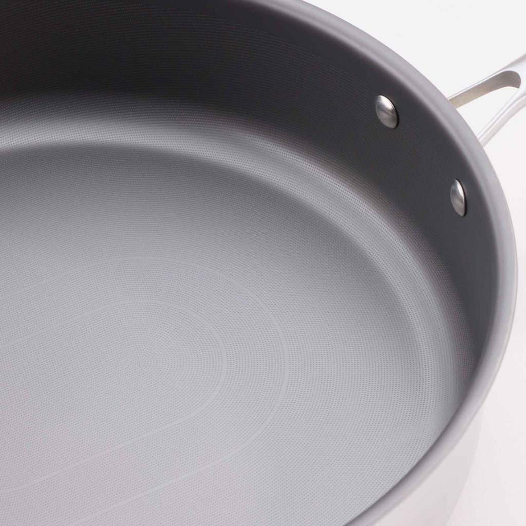 Close-up of a dark gray non-stick frying pan showing the textured interior surface and part of the silver metal handle.