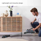 A man kneels on the floor using a cordless stick vacuum cleaner in a modern living room setting, with a wooden slat cabinet and decorative items in the background. Text at the top reads 'Lightweight and innovative design'.