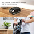 Vax vacuum cleaner battery pack on a wooden table with a person holding a vacuum cleaner.