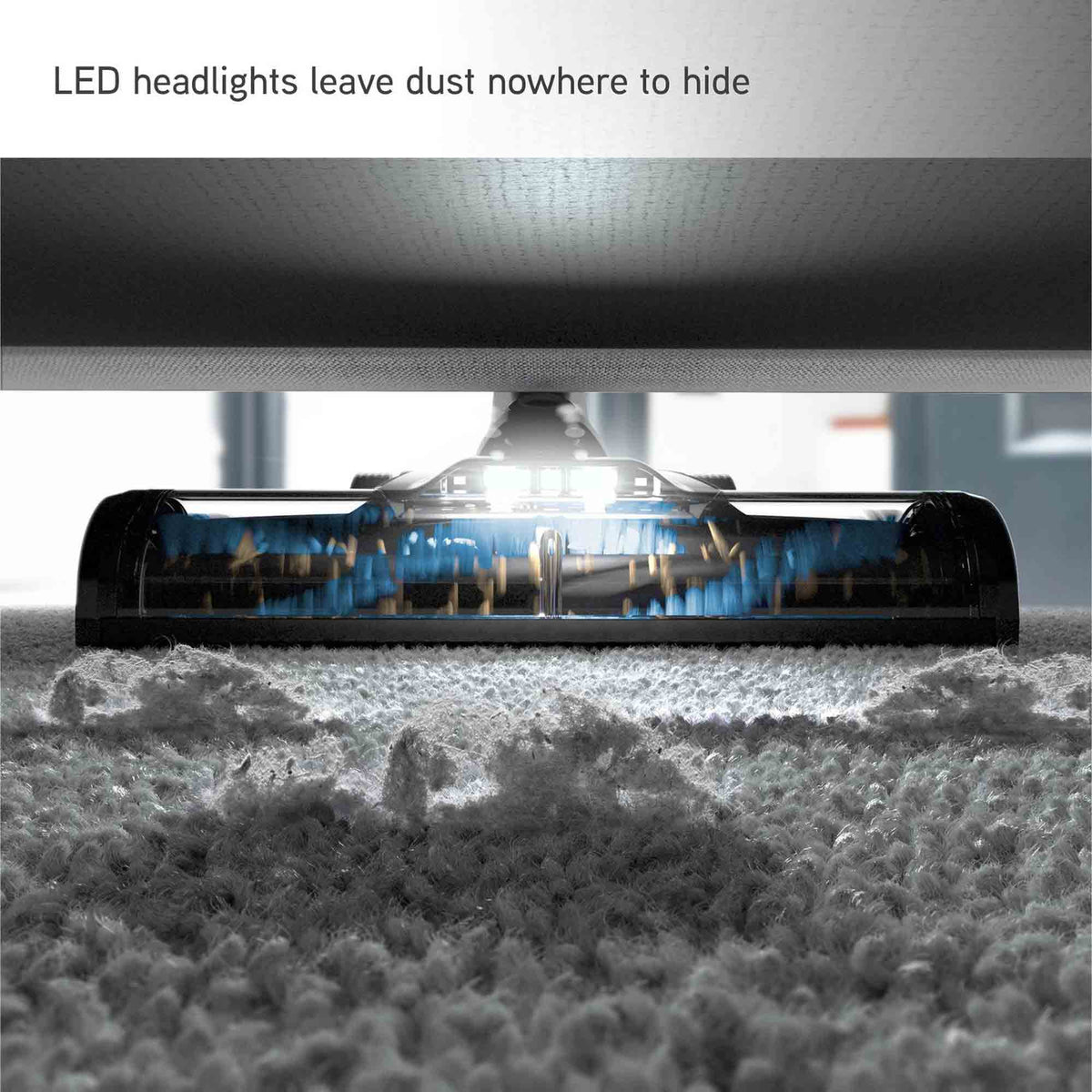A close-up of a carpet cleaning head with bright LED lights shining down onto a textured carpet. The text at the top reads 'LED headlights leave dust nowhere to hide'.