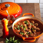 Volcanic Le Creuset dish with meatball dish on a wooden table