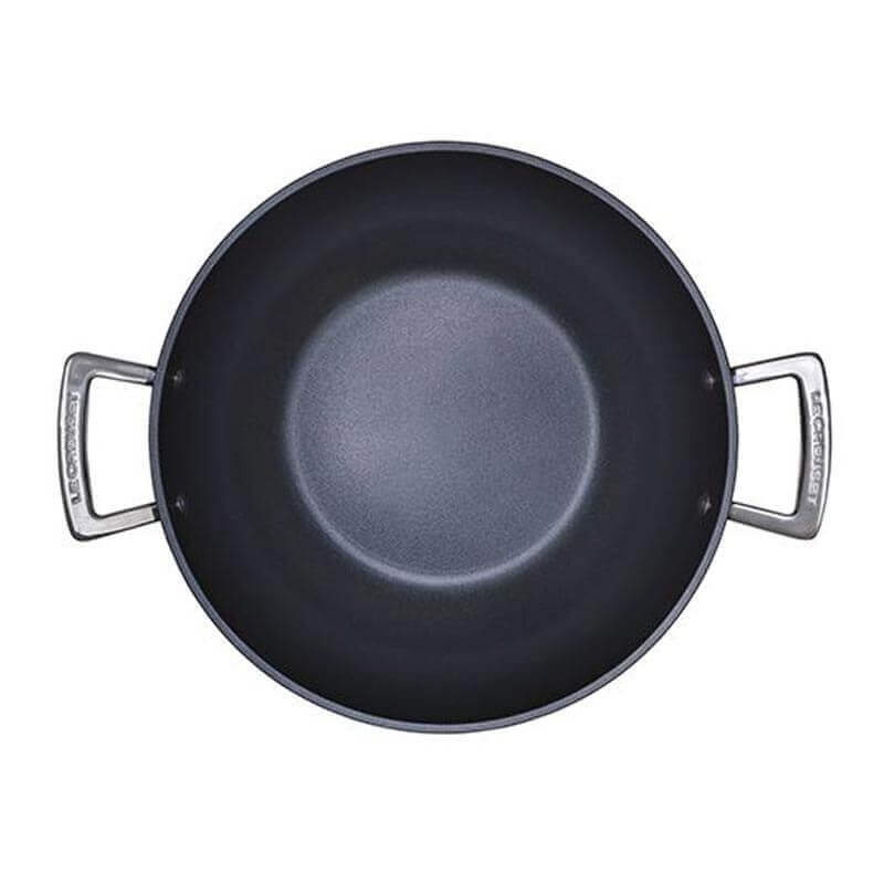 Black wok with silver handles on a white background